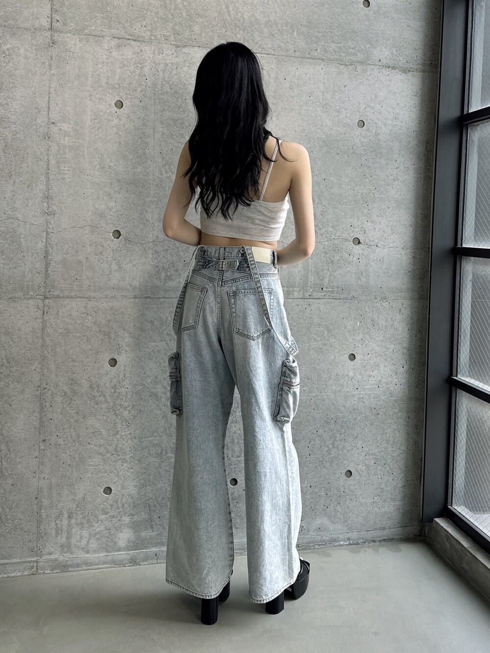 グレー系のキャミソール、ブルー系のデニムパンツ、ブラック系のサンダルを着用したレディースの夏コーディネートの2枚目の写真