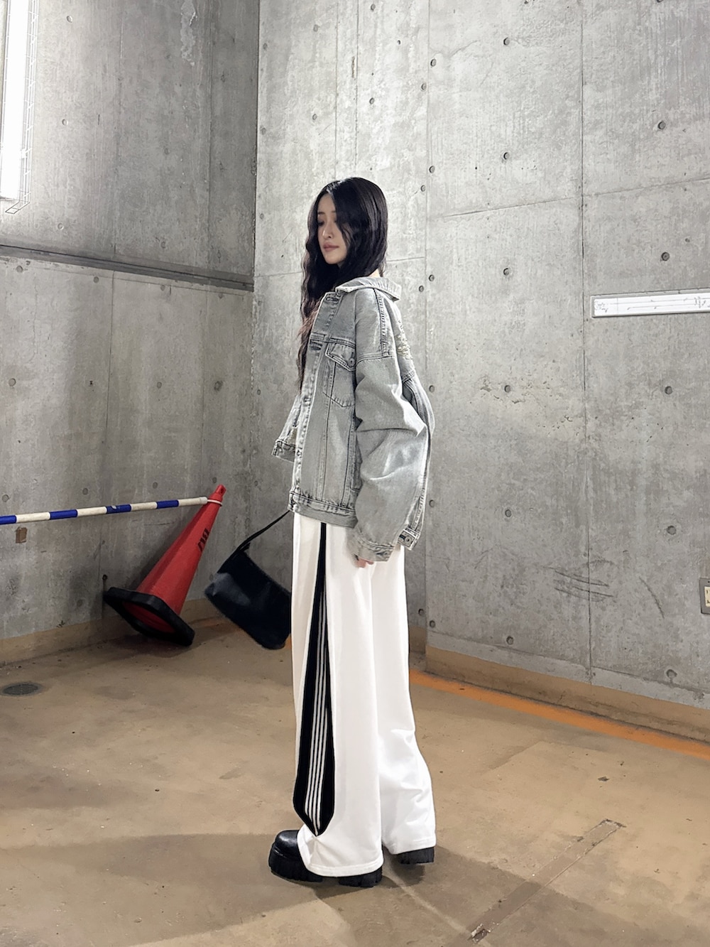 ブルー系のデニムジャケット、ブラック系のTシャツ/カットソー、ホワイト系のスウェットパンツを着用したレディースの春コーディネートの4枚目の写真