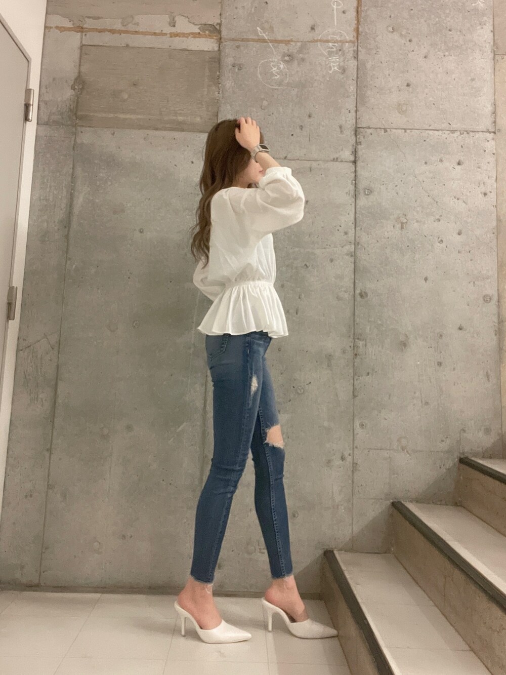 ブルー系のデニムパンツ、ホワイト系のシャツ/ブラウス、ホワイト系のパンプスを着用したレディースの冬コーディネートの4枚目の写真