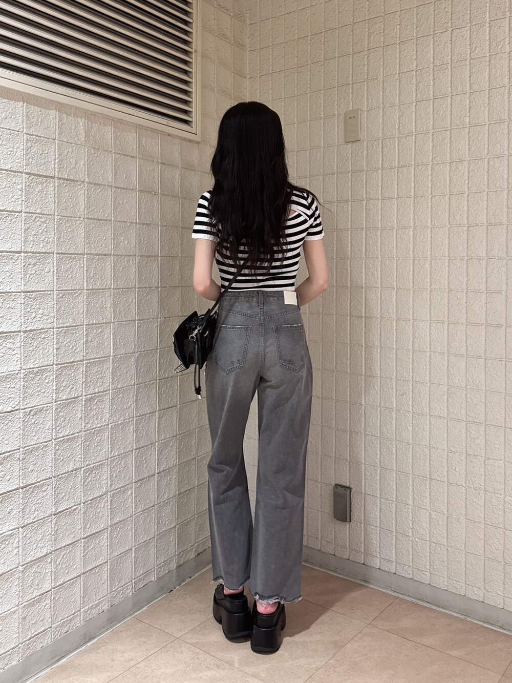 その他のニット/セーター、グレー系のデニムパンツ、ブラック系のサンダルを着用したレディースの春コーディネートの3枚目の写真
