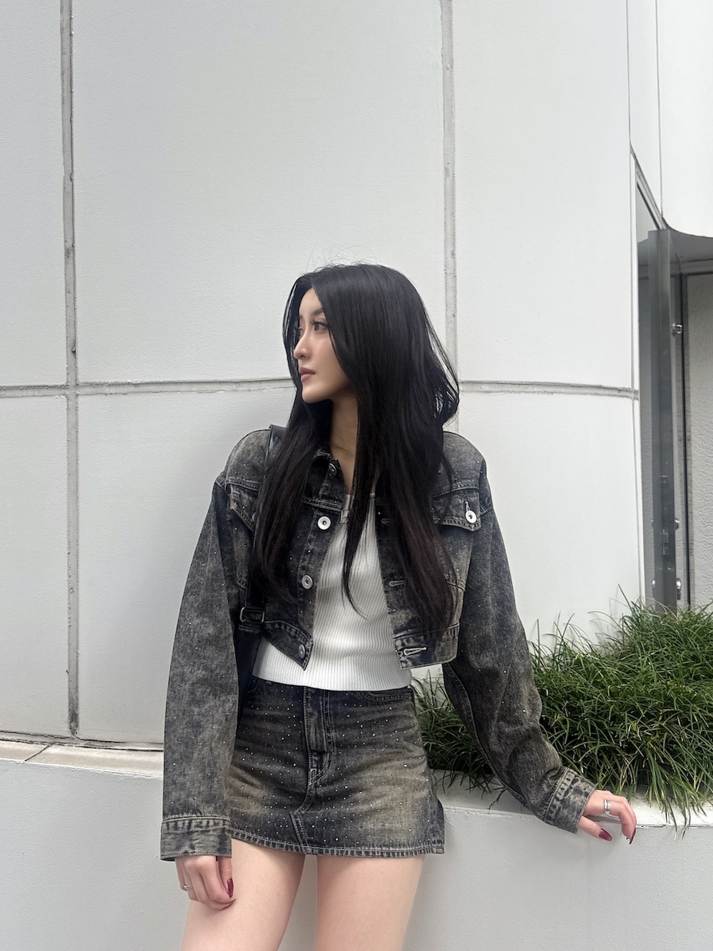 ブラック系のハンドバッグ、ブルー系のデニムジャケット、ブルー系のデニムスカートを着用したレディースの秋コーディネートの3枚目の写真