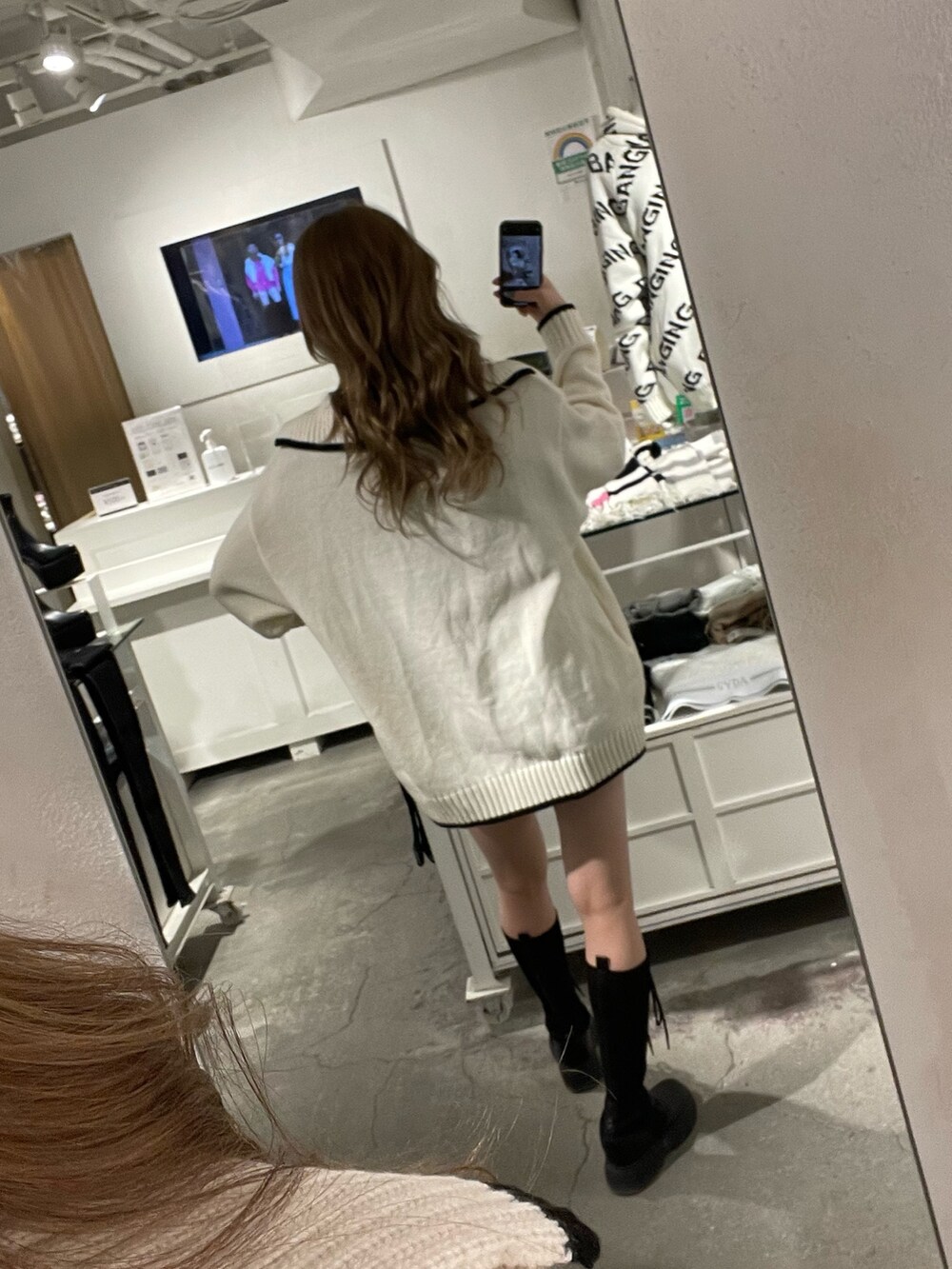 ホワイト系のニット/セーター、ブラック系のスカート、ブラック系のブーツを着用したレディースの冬コーディネートの5枚目の写真