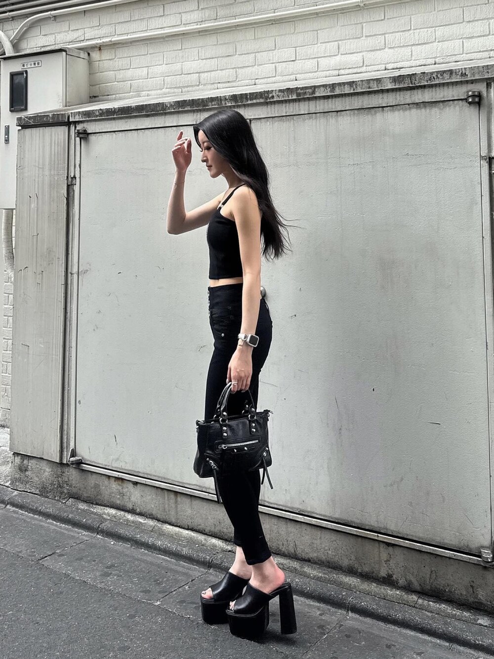 ブラック系のデニムパンツ、ブラック系のキャミソール、ブラック系のサンダルを着用したレディースの夏コーディネートの3枚目の写真