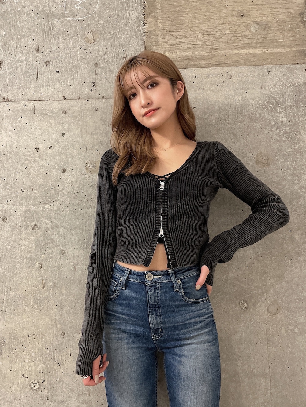 ブラック系のキャミソール、ブラック系のニット/セーター、ブルー系のデニムパンツを着用したレディースの秋コーディネートの2枚目の写真