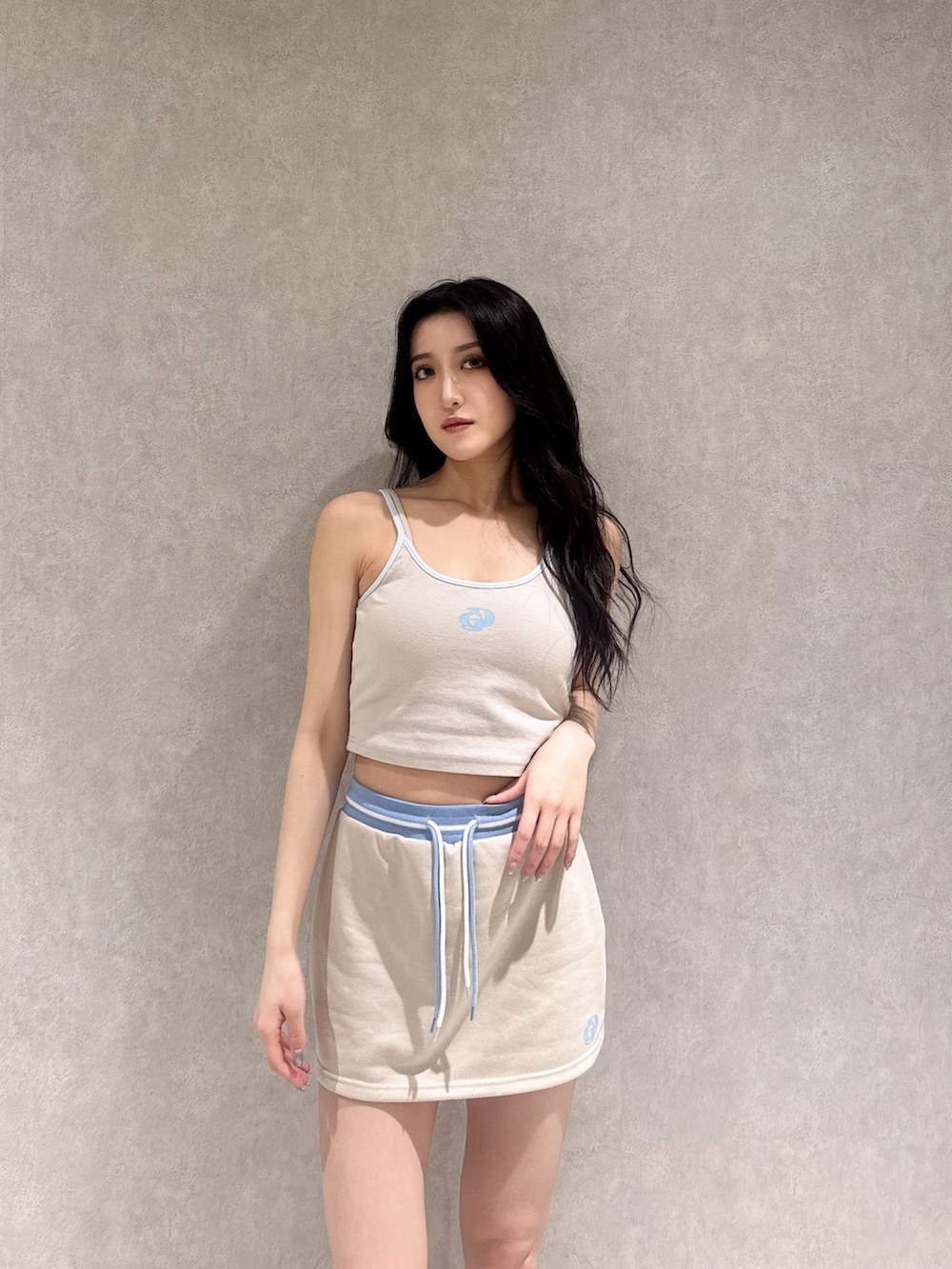 ベージュ系のスカート、ベージュ系のキャミソール、ホワイト系のサンダルを着用したレディースの夏コーディネートの2枚目の写真