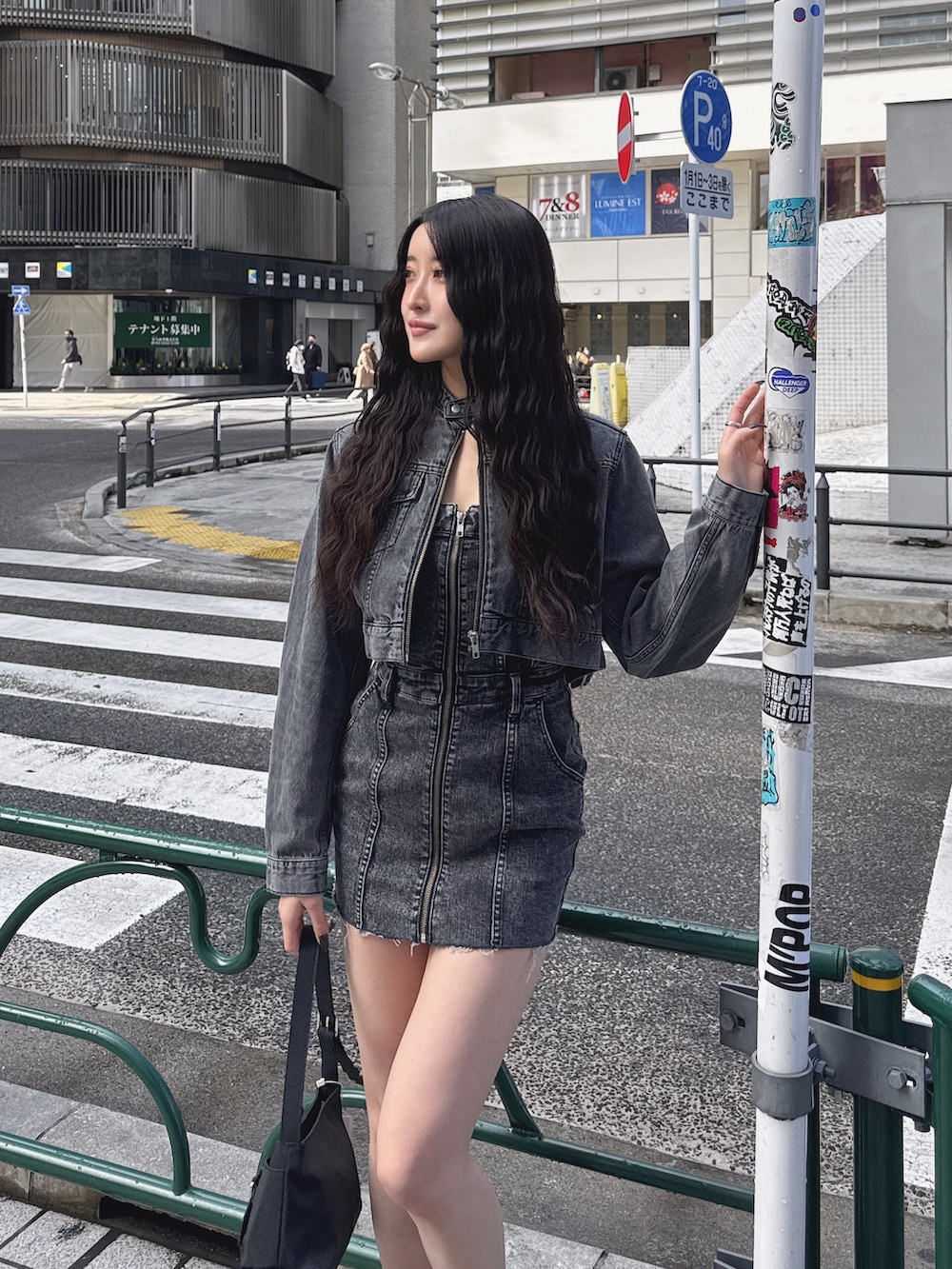 ブラック系のワンピース、ブラック系のデニムジャケット、ブラック系のハンドバッグを着用したレディースの春コーディネートの6枚目の写真