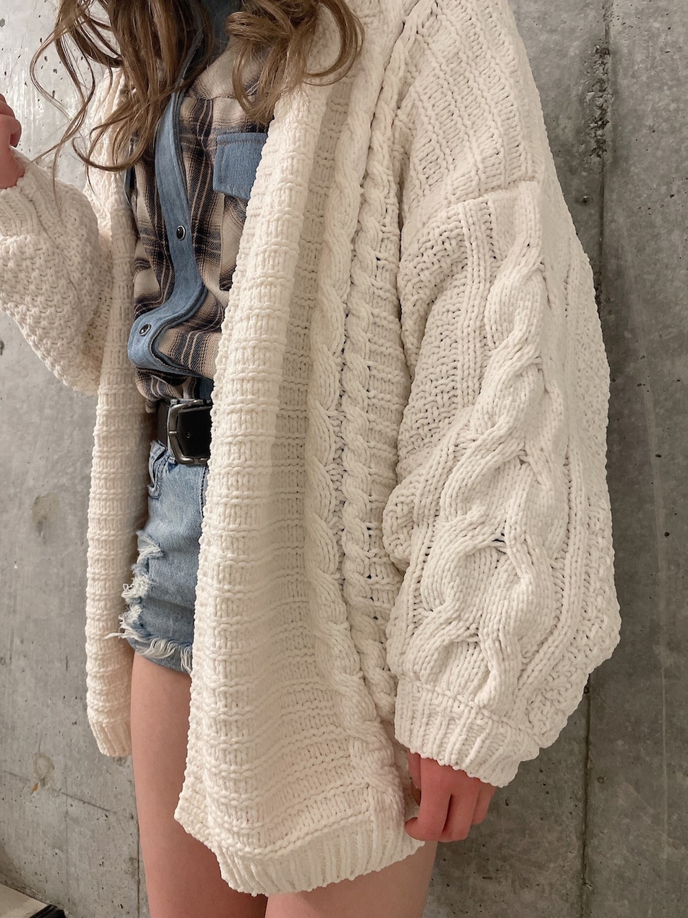 ホワイト系のカーディガン/ボレロ、ホワイト系のシャツ/ブラウス、ブラック系のブーツを着用したレディースの冬コーディネートの5枚目の写真