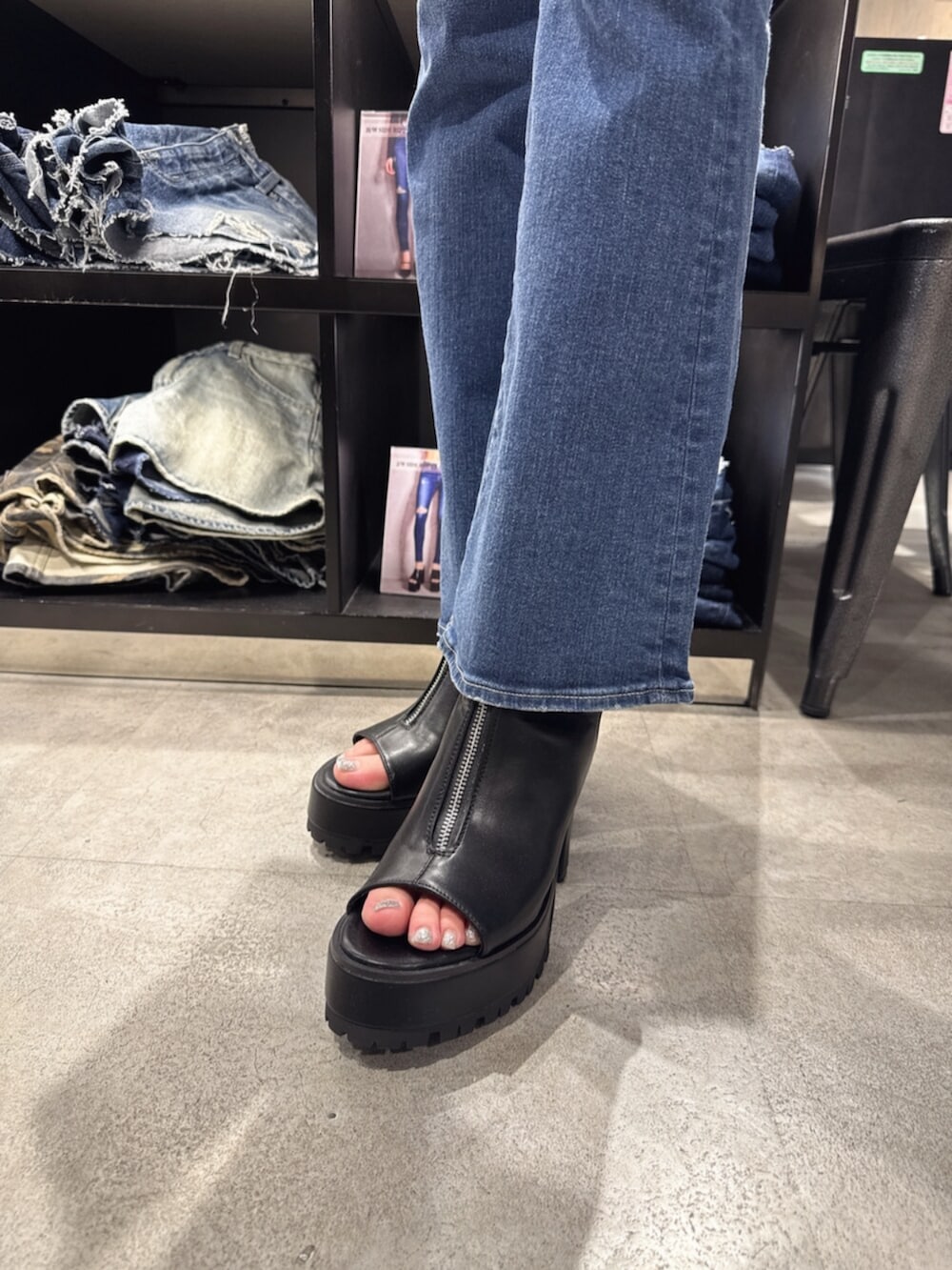 ブラック系のハンドバッグ、ブラック系のニット/セーター、ブルー系のデニムパンツを着用したレディースの夏コーディネートの8枚目の写真