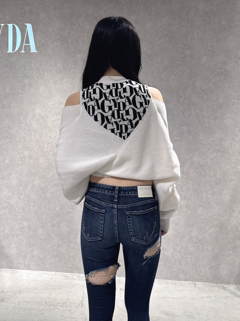 ホワイト系のニット/セーター、ブルー系のデニムパンツ、ブラック系のブーツを着用したレディースの秋コーディネートの6枚目の写真