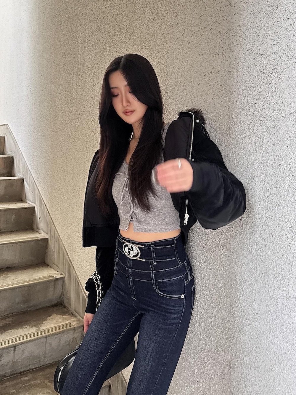 ブラック系のブルゾン、グレー系のTシャツ/カットソー、ブルー系のデニムパンツを着用したレディースの秋コーディネートの2枚目の写真