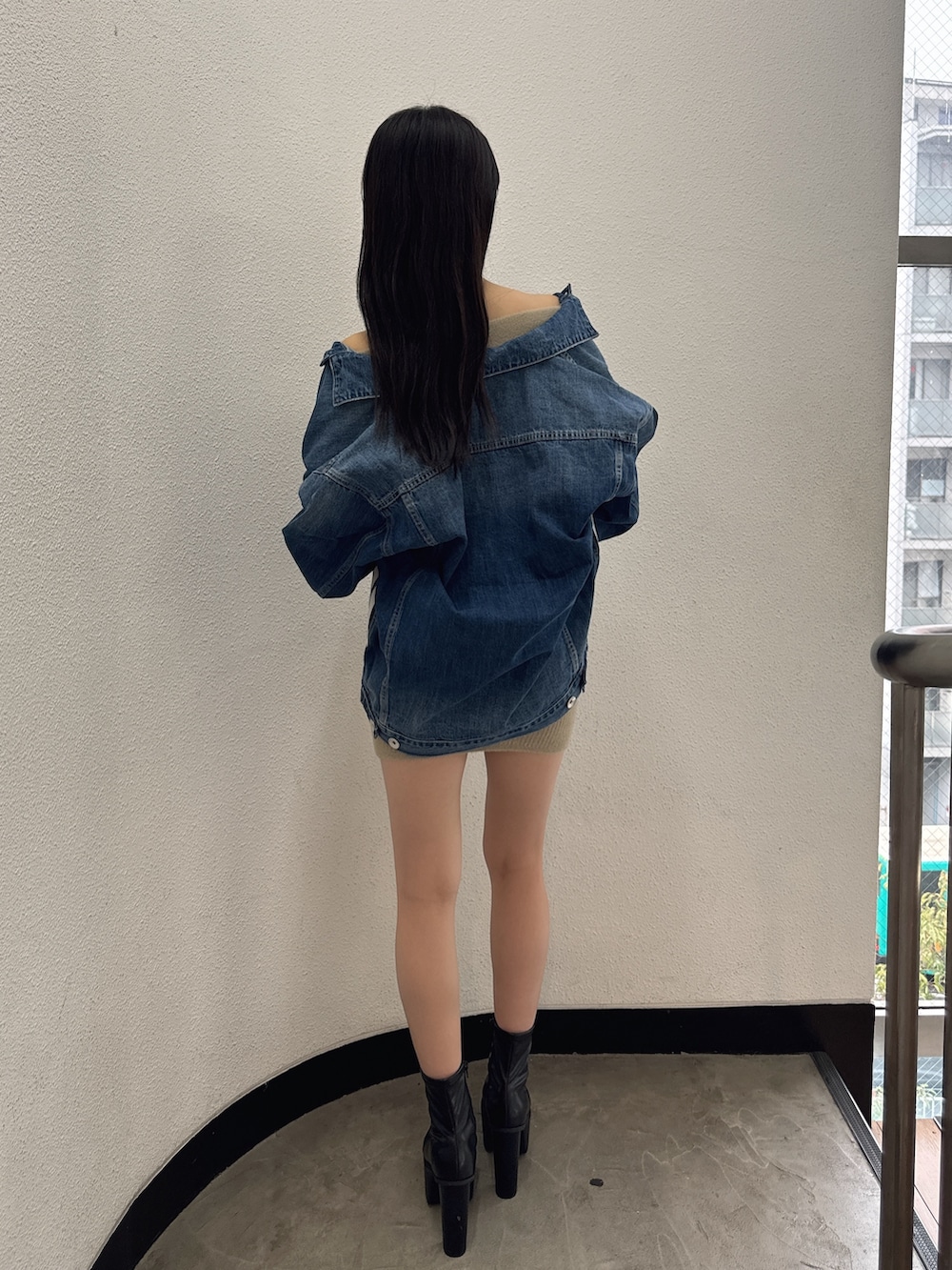 ブルー系のデニムジャケット、ベージュ系のワンピース、ブラック系のブーツを着用したレディースの秋コーディネートの2枚目の写真