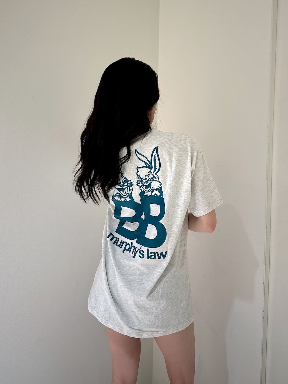 グレー系のTシャツ/カットソー、ブラック系のデニムスカート、ブラック系のサンダルを着用したレディースの夏コーディネートの4枚目の写真