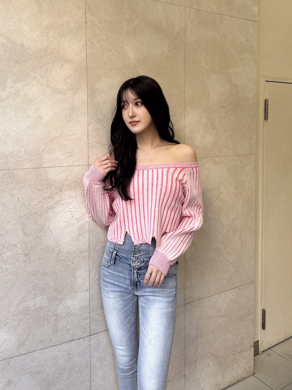 ホワイト系のパンプス、ブルー系のデニムパンツ、ピンク系のニット/セーターを着用したレディースの冬コーディネートの2枚目の写真