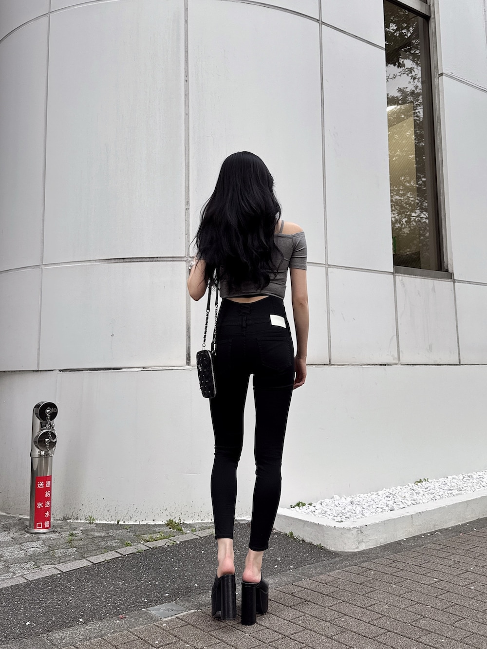 グレー系のTシャツ/カットソー、ブラック系のサンダル、ブラック系のデニムパンツを着用したレディースの春コーディネートの2枚目の写真