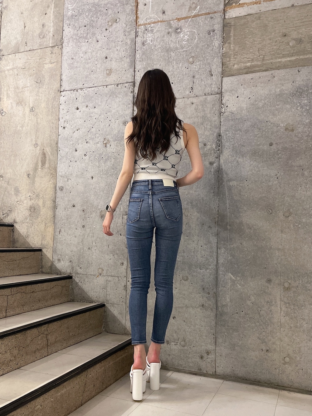 ホワイト系のニット/セーター、ブルー系のデニムパンツ、ホワイト系のサンダルを着用したレディースの春コーディネートの3枚目の写真