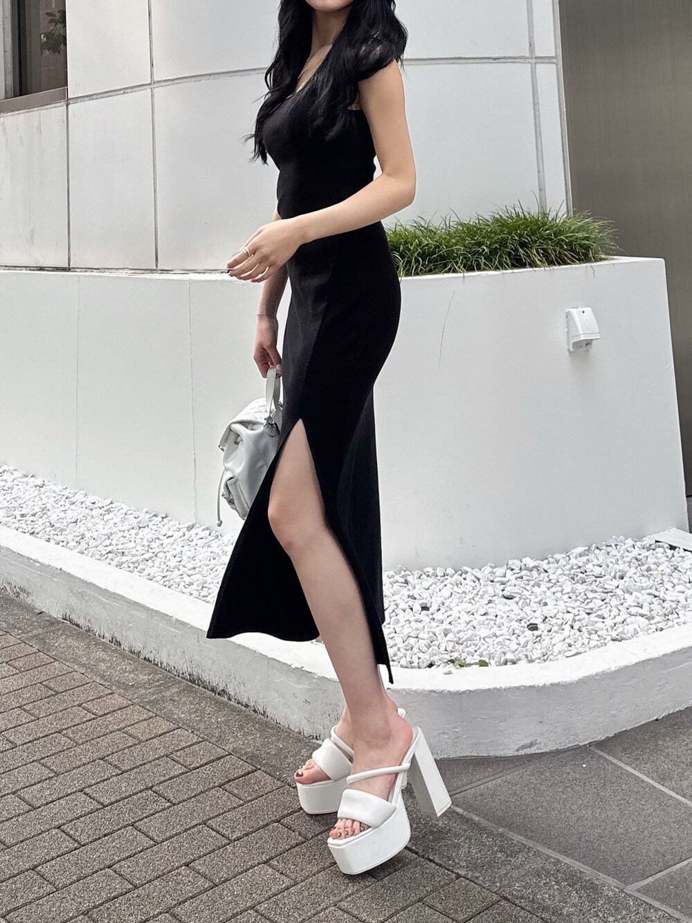 ブラック系のワンピース、ホワイト系のサンダル、ホワイト系のバックパック/リュックを着用したレディースの夏コーディネートの2枚目の写真