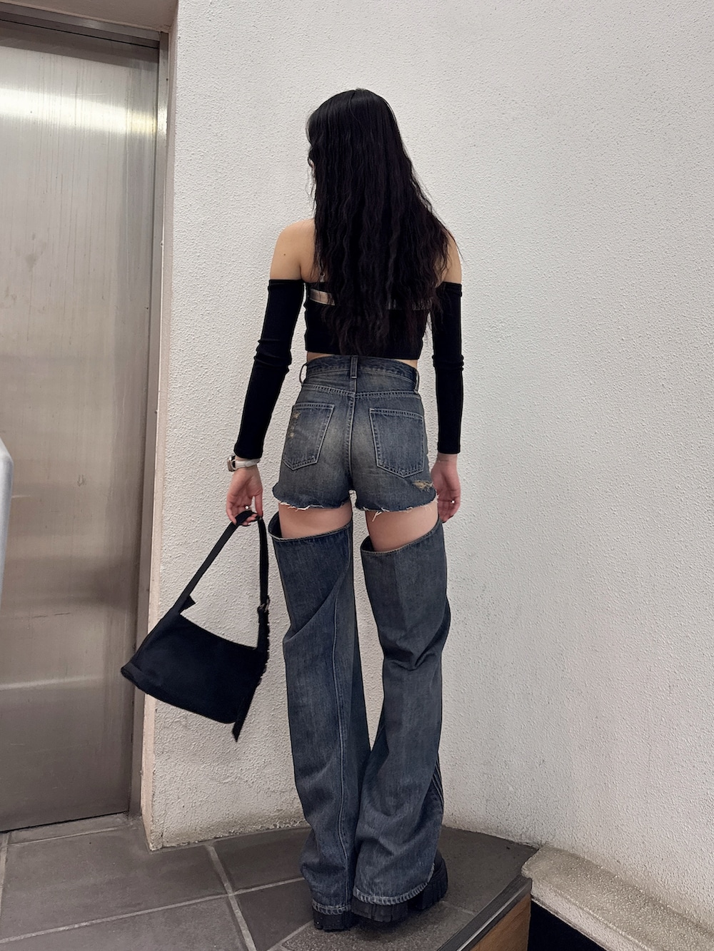 ブラック系のTシャツ/カットソー、ブルー系のデニムパンツ、ブラック系のハンドバッグを着用したレディースの春コーディネートの3枚目の写真