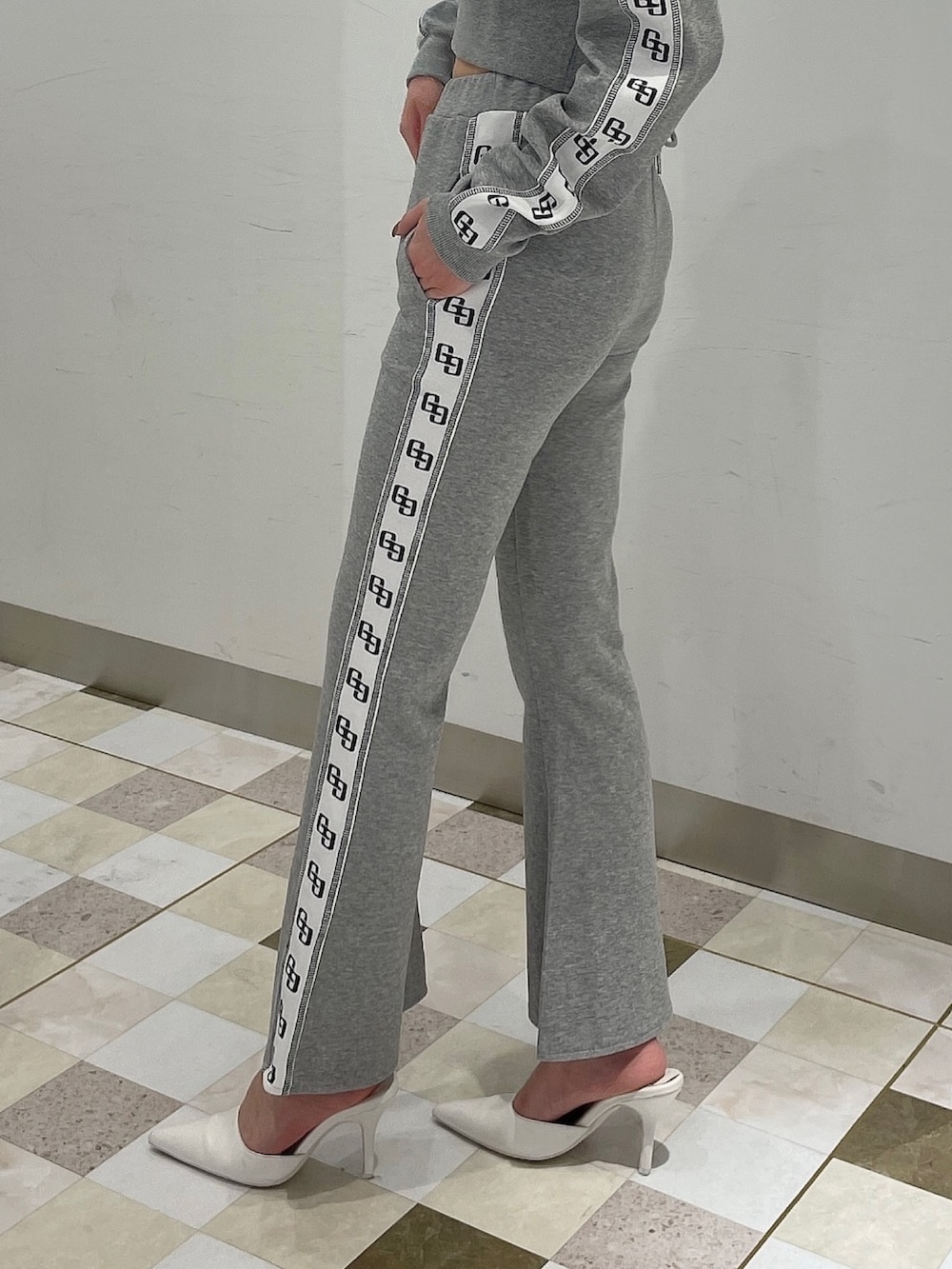 グレー系のパーカー、グレー系のその他パンツ、ホワイト系のパンプスを着用したレディースの冬コーディネートの5枚目の写真