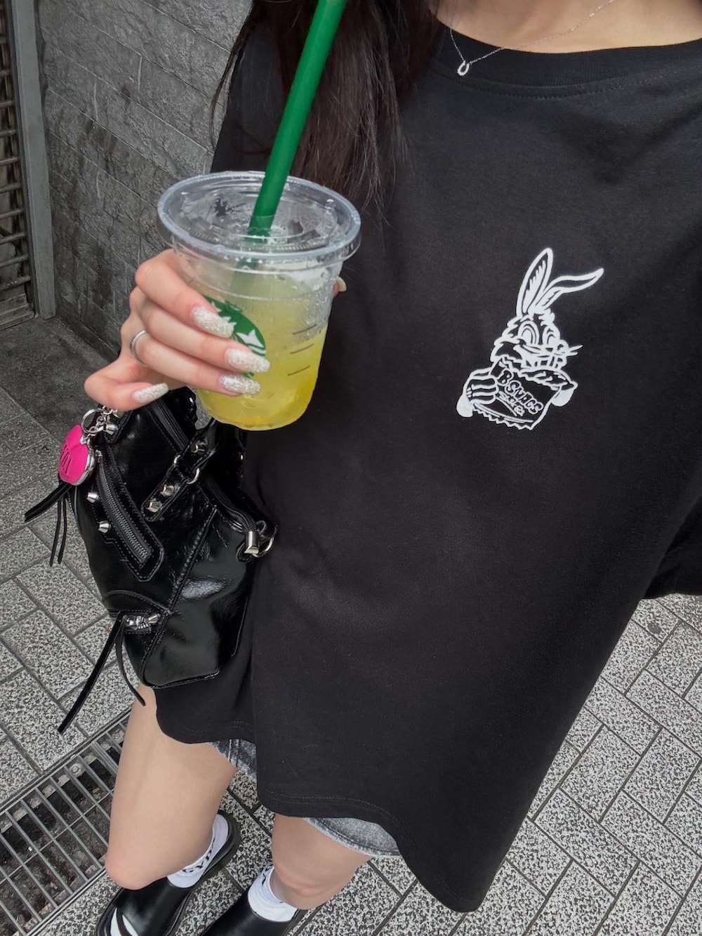 ブラック系のTシャツ/カットソー、ブラック系のデニムスカート、ブラック系のサンダルを着用したレディースの夏コーディネートの3枚目の写真