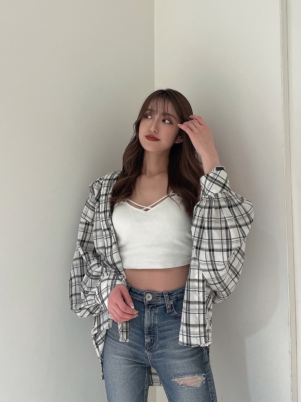 ブルー系のデニムパンツ、ホワイト系のシャツ/ブラウス、ホワイト系のキャミソールを着用したレディースの春コーディネートの3枚目の写真