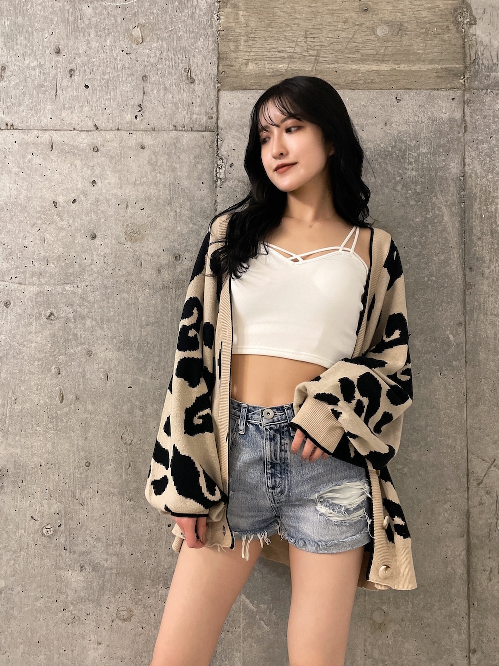 ブルー系のデニムパンツ、ホワイト系のキャミソール、ベージュ系のカーディガン/ボレロを着用したレディースの夏コーディネートの4枚目の写真