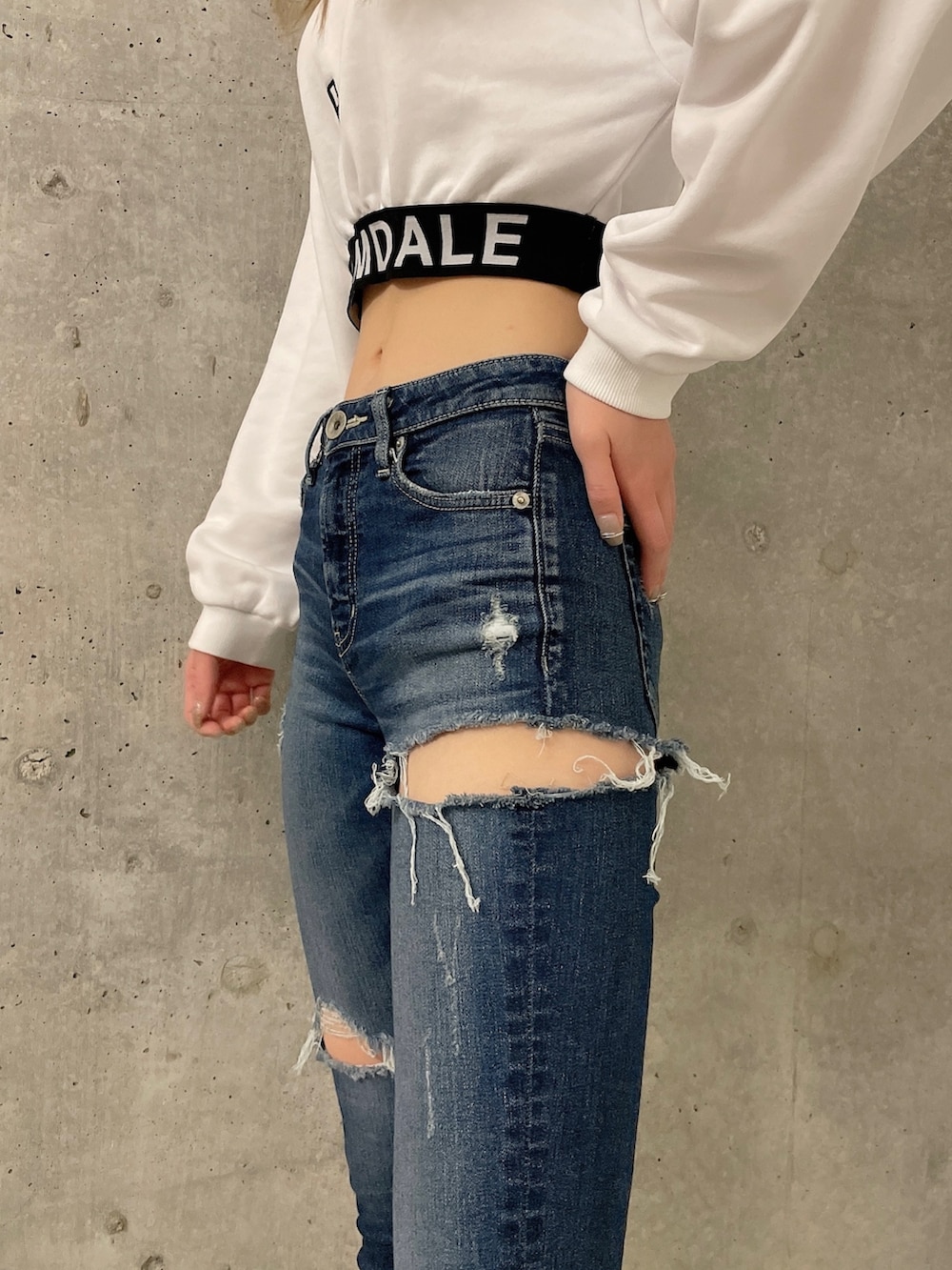 ホワイト系のスウェット、ブルー系のデニムパンツ、ホワイト系のスニーカーを着用したレディースの冬コーディネートの5枚目の写真