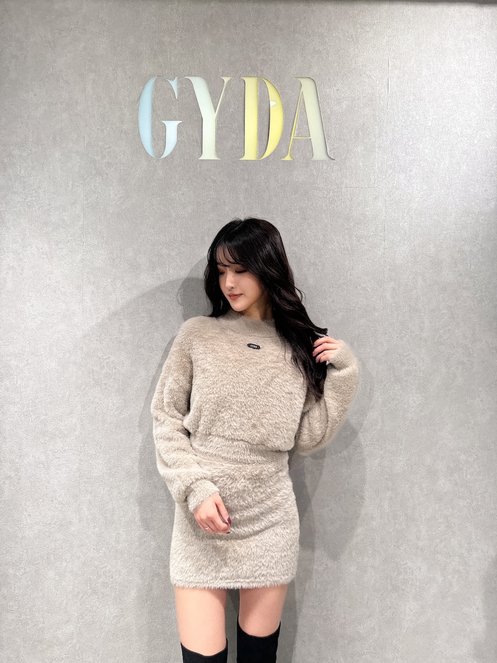 ベージュ系のニット/セーター、ベージュ系のスカート、ブラック系のブーツを着用したレディースの冬コーディネートの3枚目の写真