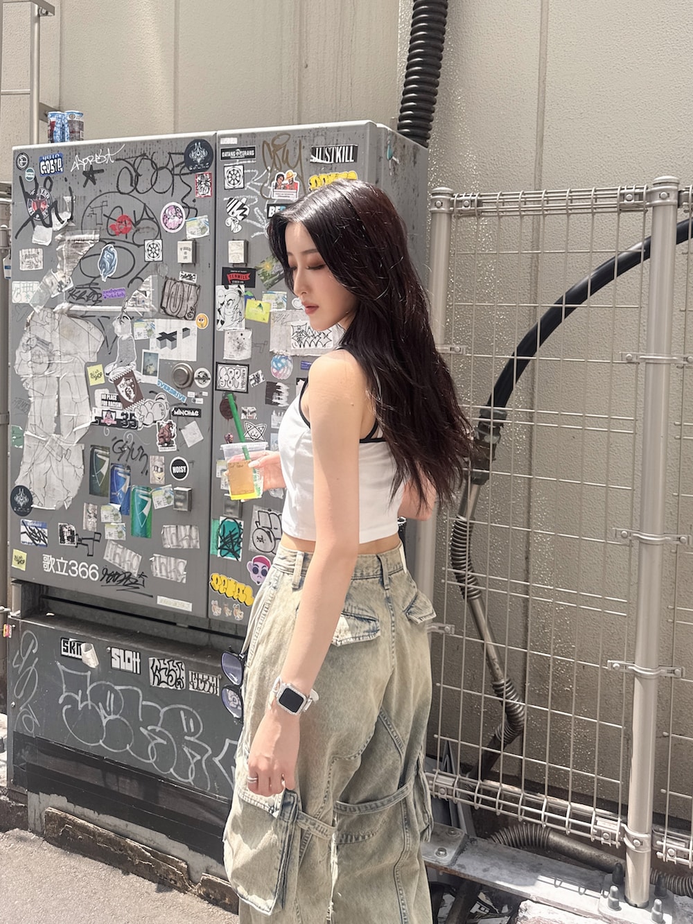 ホワイト系のキャミソール、ブルー系のデニムパンツ、ブラック系のサンダルを着用したレディースの夏コーディネートの4枚目の写真