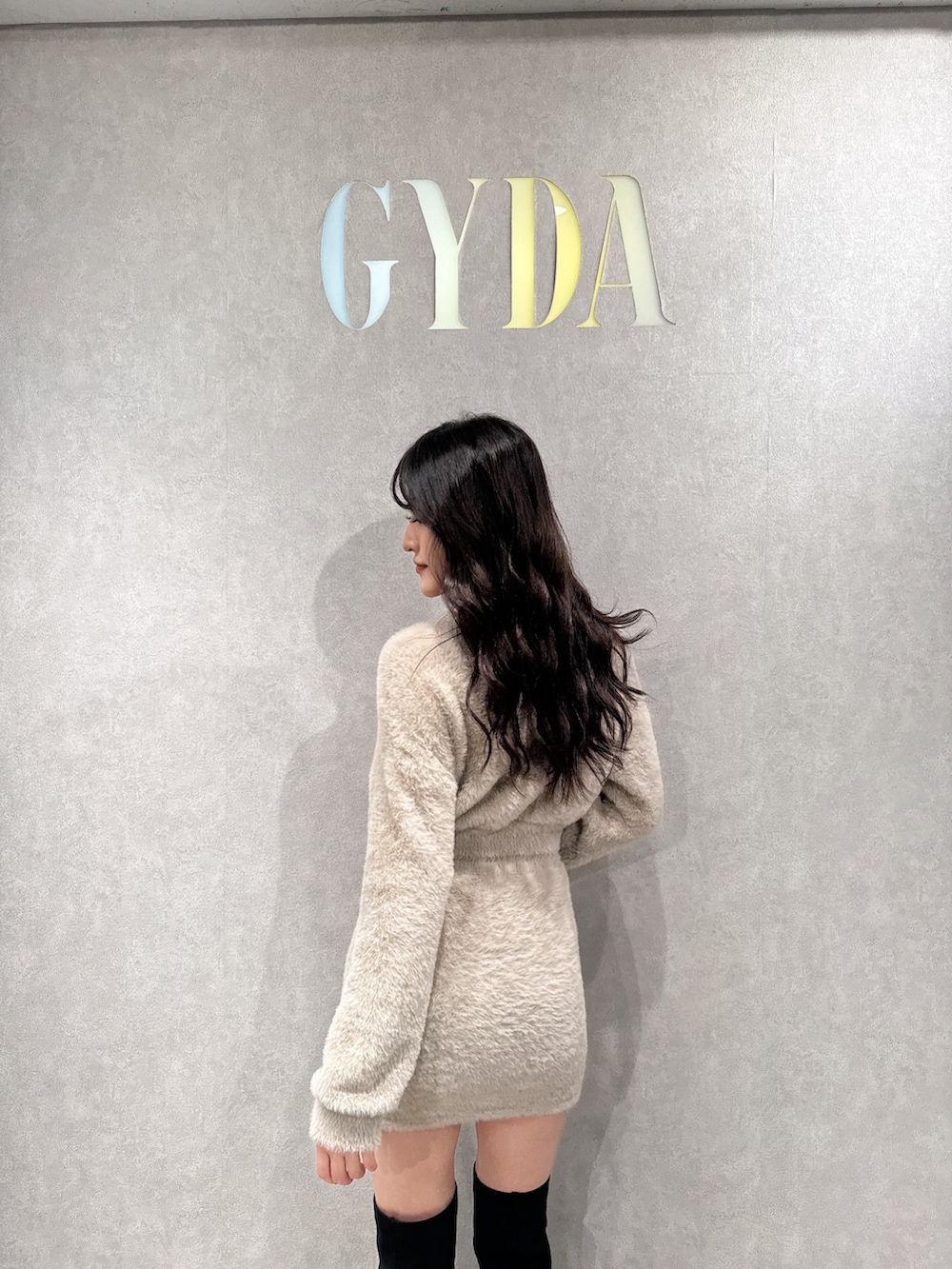 ベージュ系のニット/セーター、ベージュ系のスカート、ブラック系のブーツを着用したレディースの冬コーディネートの5枚目の写真