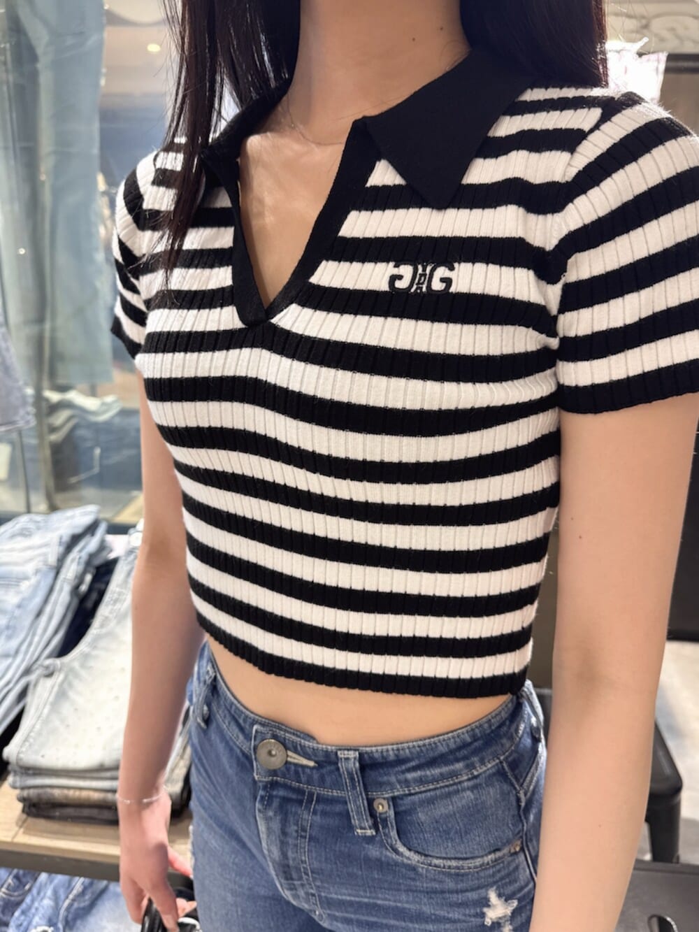 ブラック系のハンドバッグ、ブルー系のデニムパンツ、ブラック系のサンダルを着用したレディースの夏コーディネートの6枚目の写真
