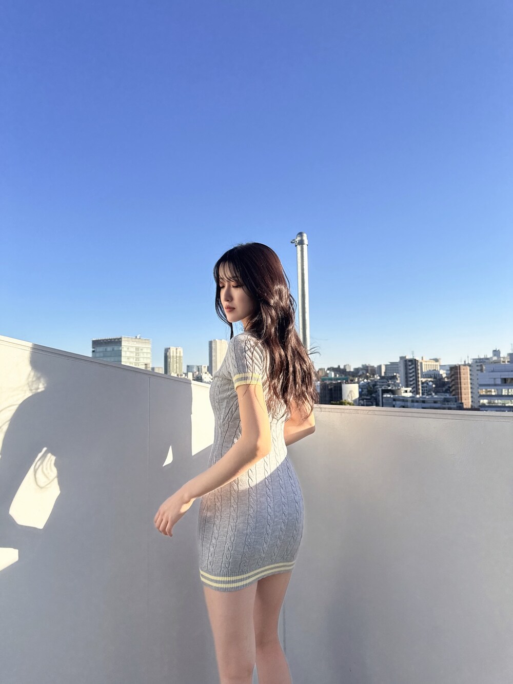 グレー系のワンピース、ホワイト系のサンダルを着用したレディースの春コーディネートの3枚目の写真