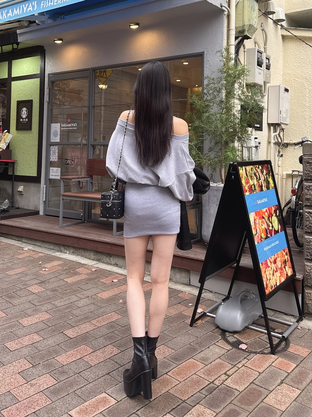 グレー系のワンピース、ブラック系のブーツを着用したレディースの冬コーディネートの4枚目の写真