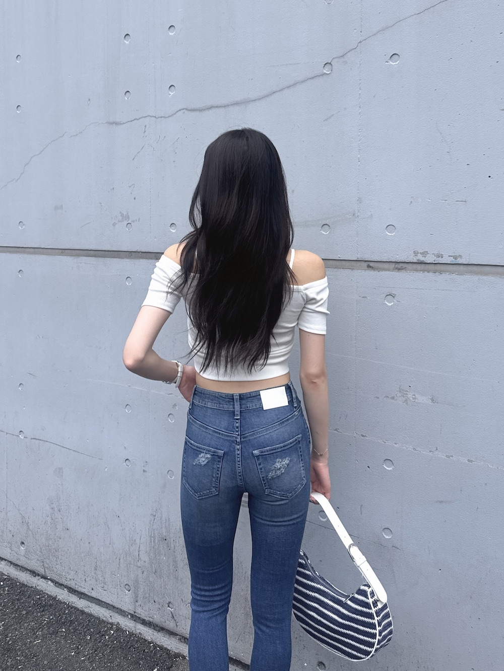 ホワイト系のTシャツ/カットソー、ブルー系のデニムパンツ、ホワイト系のサンダルを着用したレディースの夏コーディネートの3枚目の写真