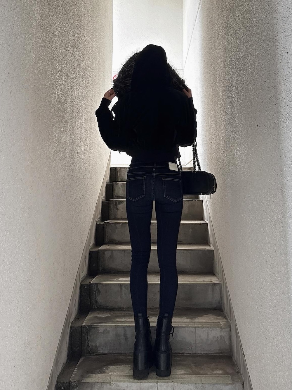 ブラック系のブルゾン、グレー系のTシャツ/カットソー、ブルー系のデニムパンツを着用したレディースの秋コーディネートの3枚目の写真