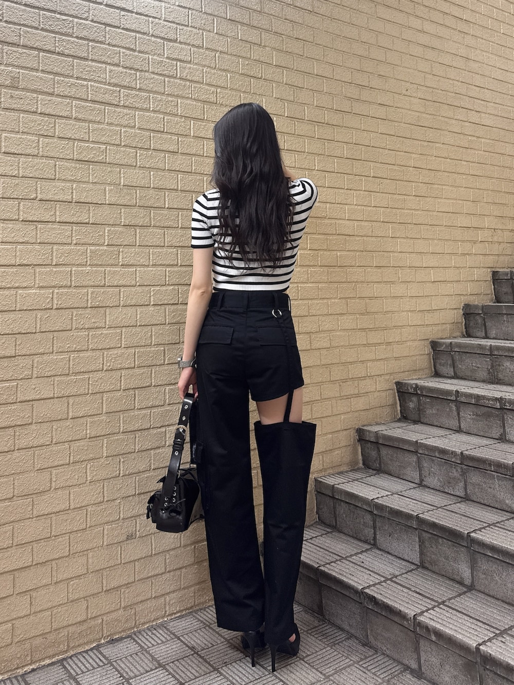 その他のニット/セーター、ブラック系のその他パンツ、ブラック系のハンドバッグを着用したレディースの夏コーディネートの2枚目の写真