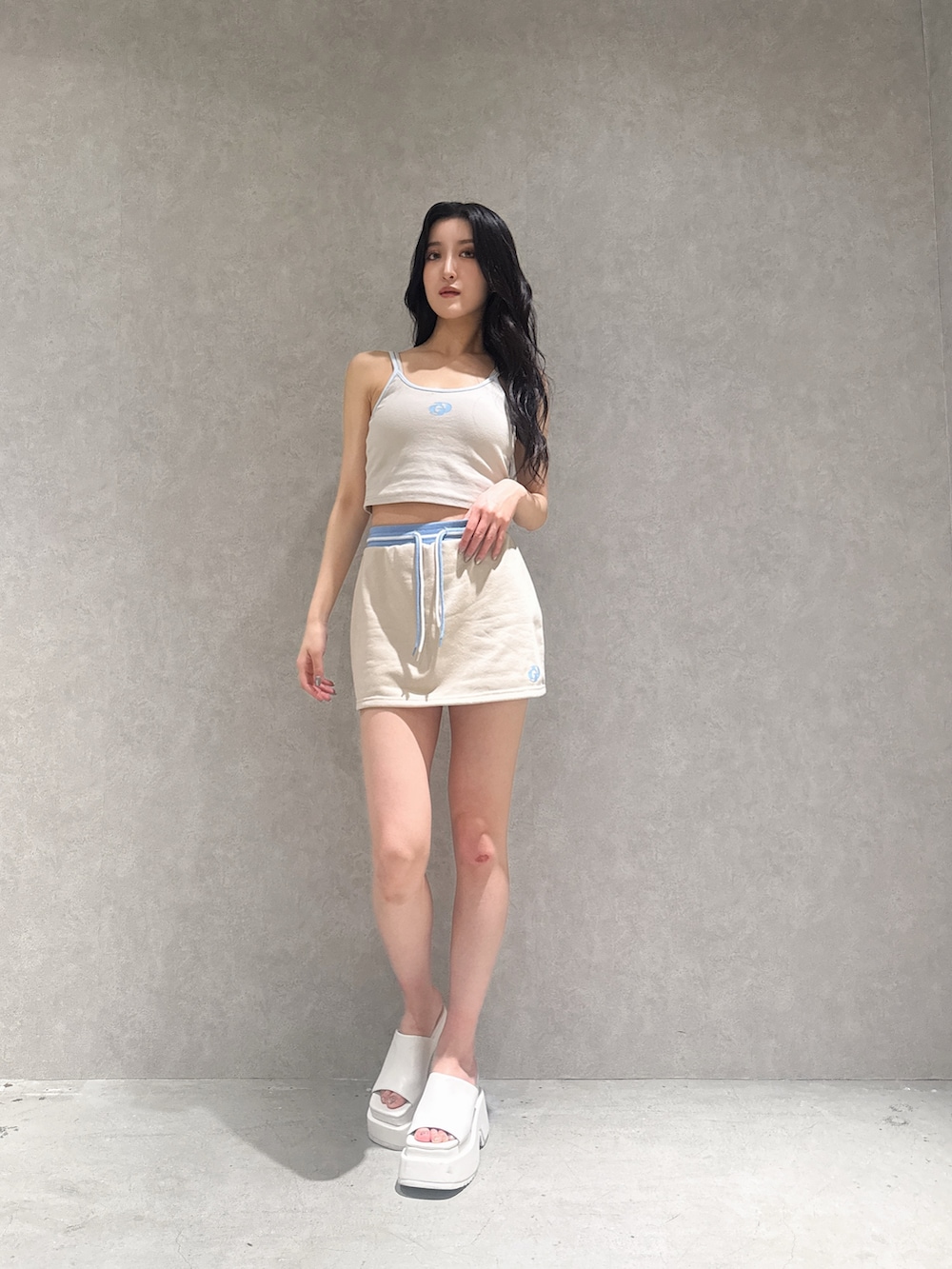 ベージュ系のスカート、ベージュ系のキャミソール、ホワイト系のサンダルを着用したレディースの夏コーディネートの7枚目の写真