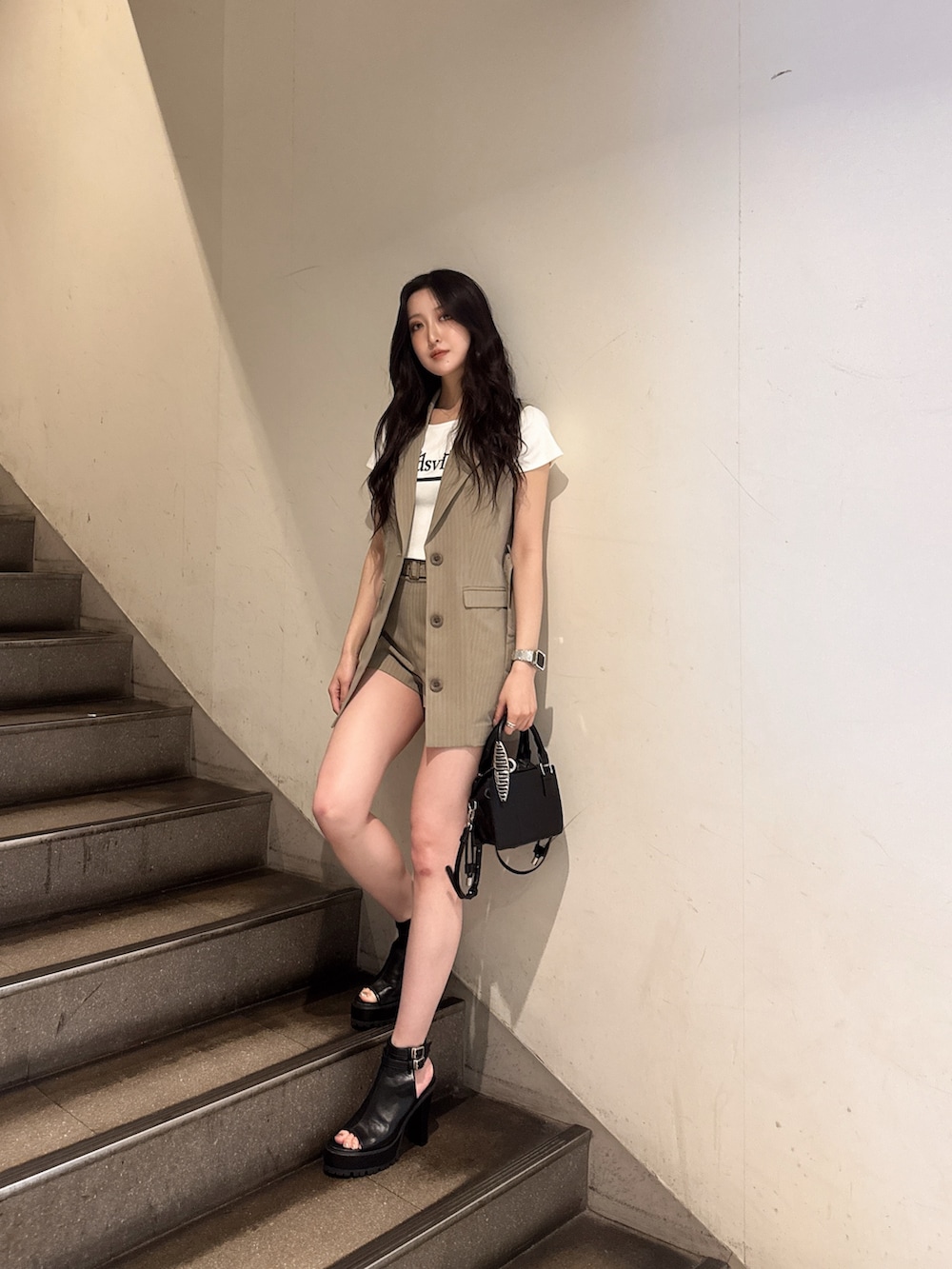 ベージュ系のベスト、ベージュ系のその他パンツ、ホワイト系のTシャツ/カットソーを着用したレディースの春コーディネートの2枚目の写真