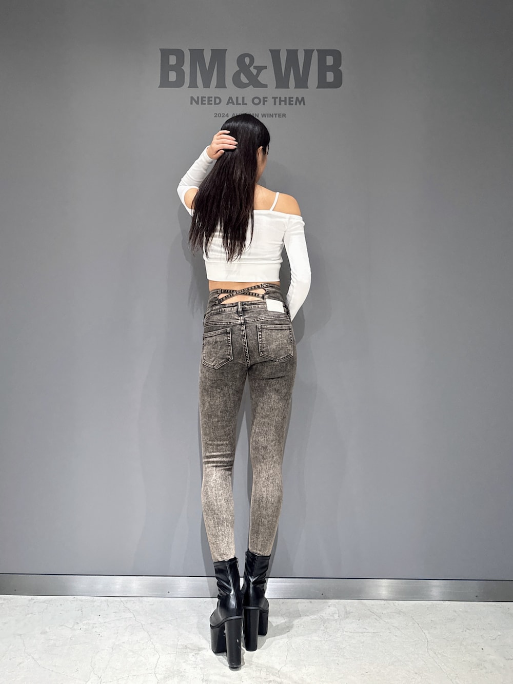 ホワイト系のTシャツ/カットソー、ブラック系のデニムパンツ、ブラック系のブーツを着用したレディースの秋コーディネートの2枚目の写真