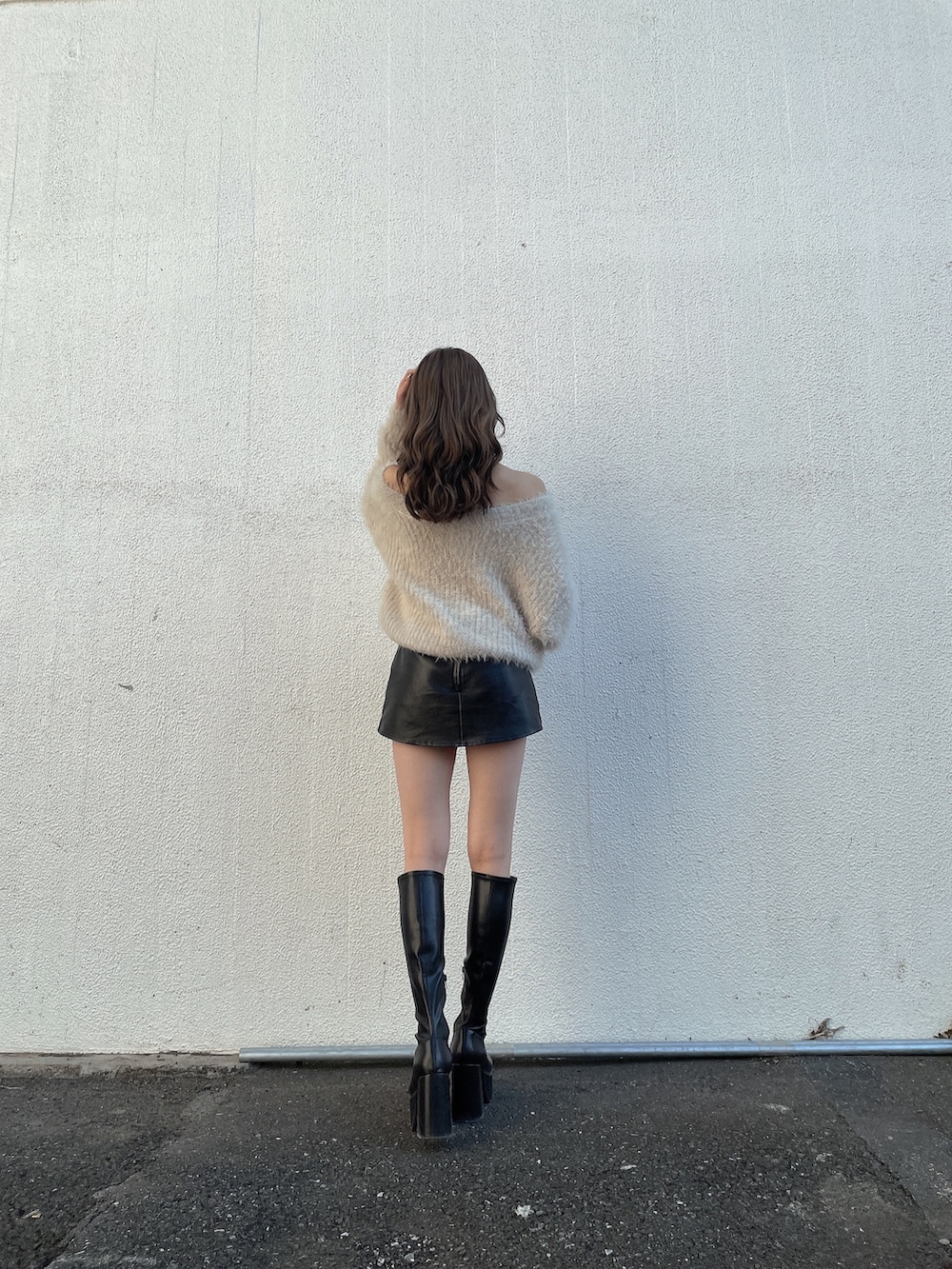 ホワイト系のニット/セーター、ブラック系のスカート、ブラック系のブーツを着用したレディースの冬コーディネートの4枚目の写真