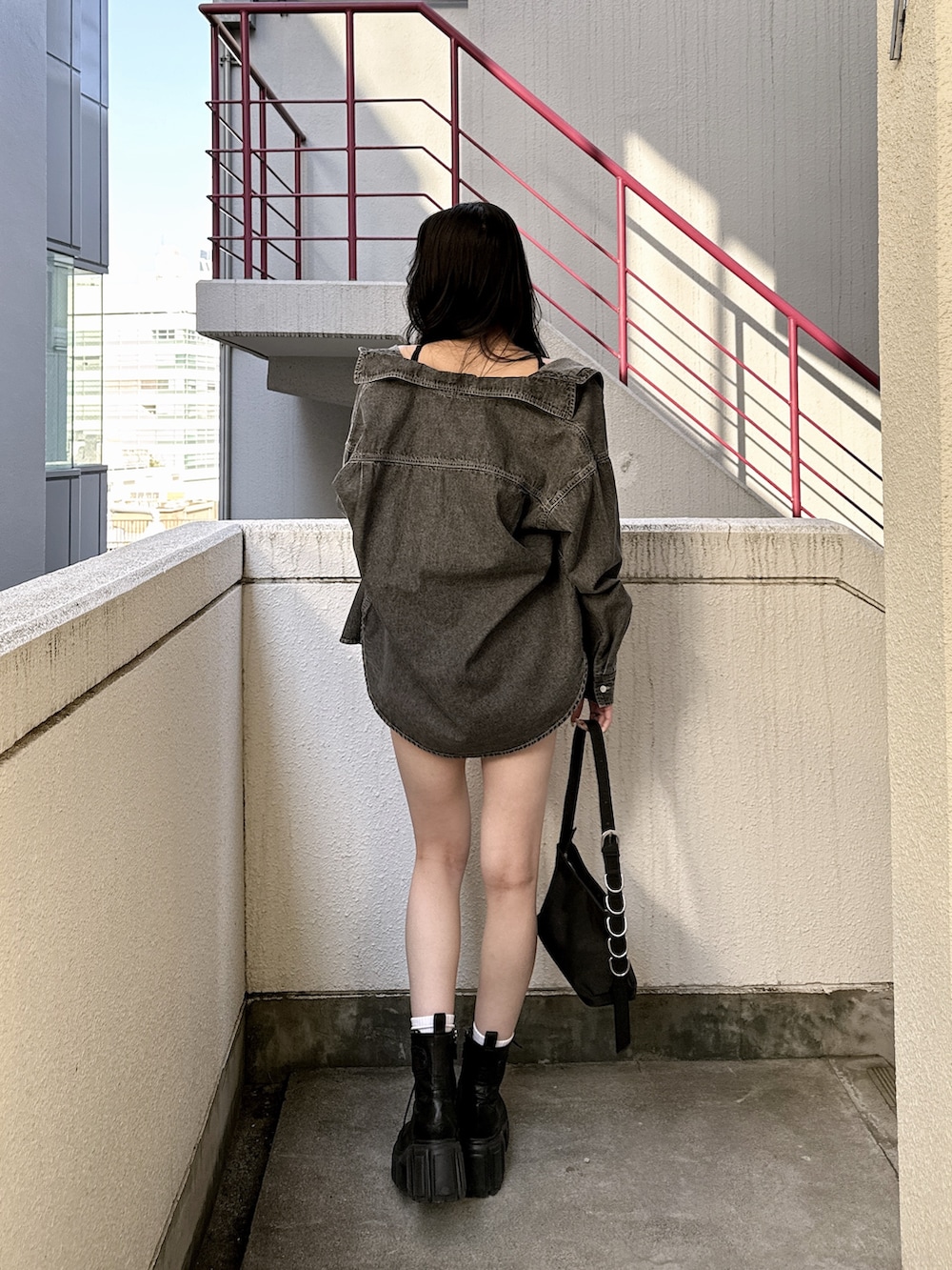 ブラック系のシャツ/ブラウス、ブラック系のスカート、ホワイト系のキャミソールを着用したレディースの春コーディネートの3枚目の写真