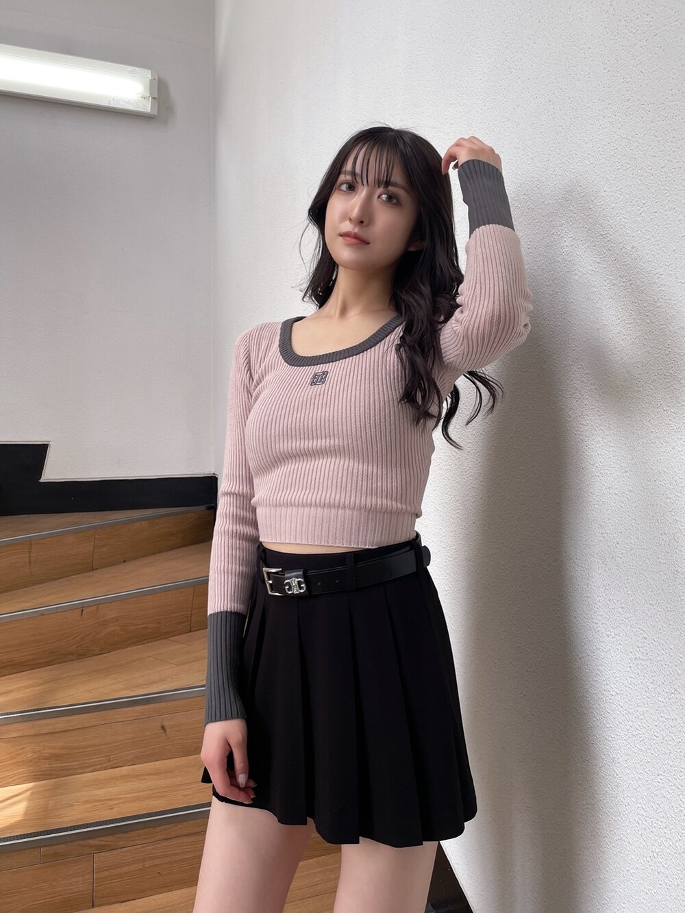 ピンク系のニット/セーター、ブラック系のスカート、ブラック系のブーツを着用したレディースの秋コーディネートの3枚目の写真