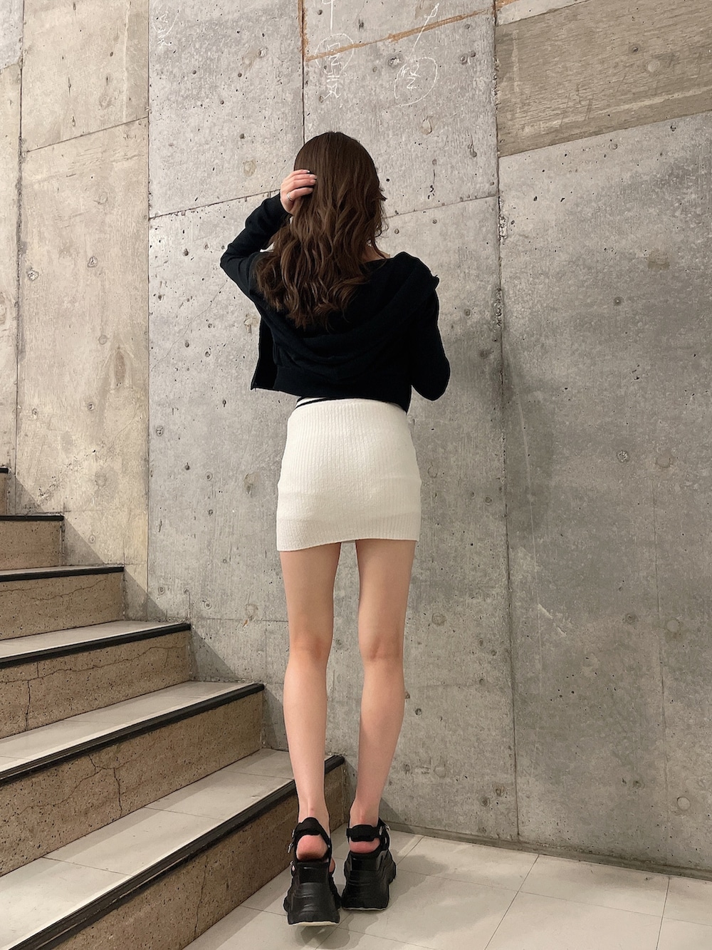 ブラック系のパーカー、ホワイト系のスカート、ホワイト系のキャミソールを着用したレディースの春コーディネートの3枚目の写真