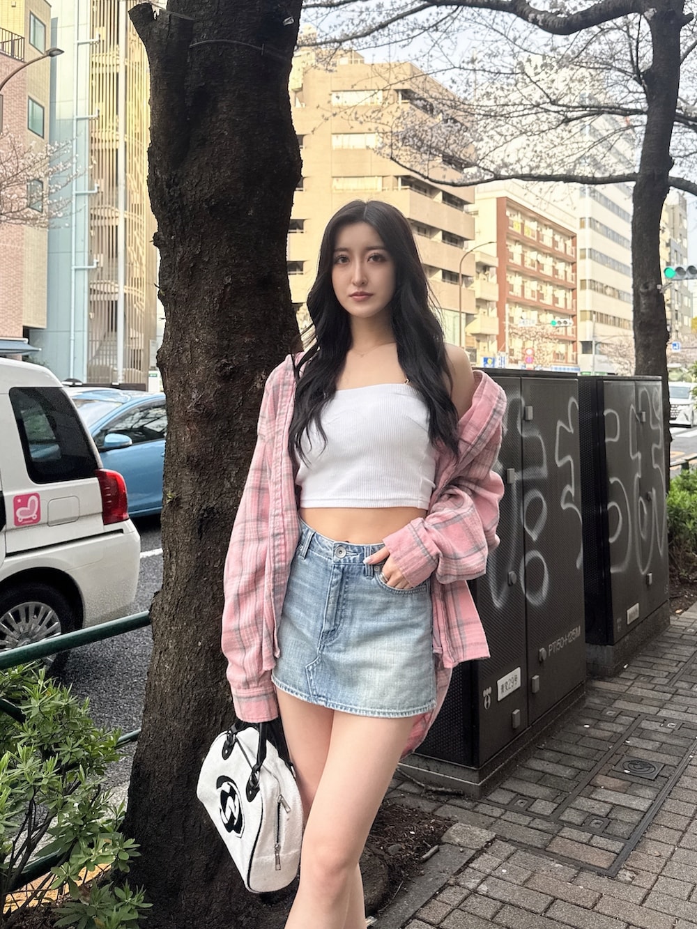 ホワイト系のキャミソール、ブルー系のデニムスカート、ホワイト系のサンダルを着用したレディースの春コーディネートの2枚目の写真