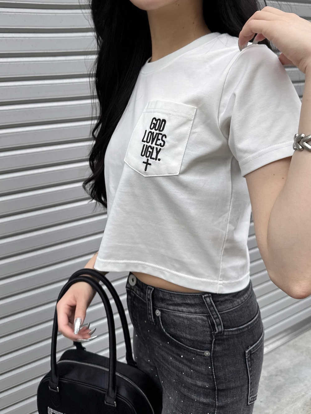 ホワイト系のTシャツ/カットソー、ブラック系のデニムパンツ、ブラック系のボストンバッグを着用したレディースの夏コーディネートの7枚目の写真