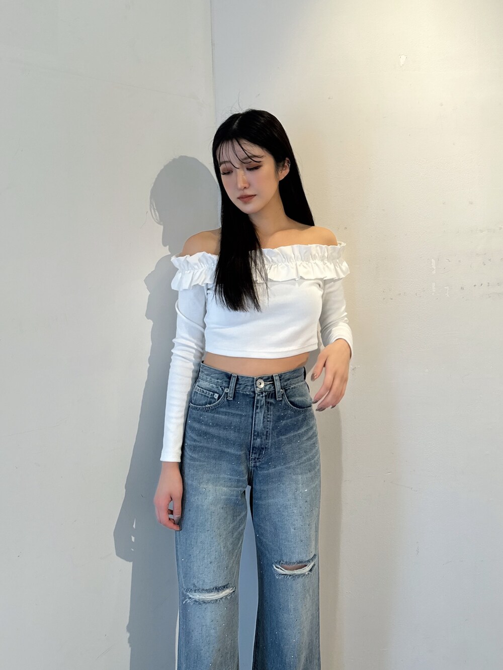 ホワイト系のTシャツ/カットソー、ブルー系のデニムパンツ、ホワイト系のパンプスを着用したレディースの冬コーディネートの3枚目の写真