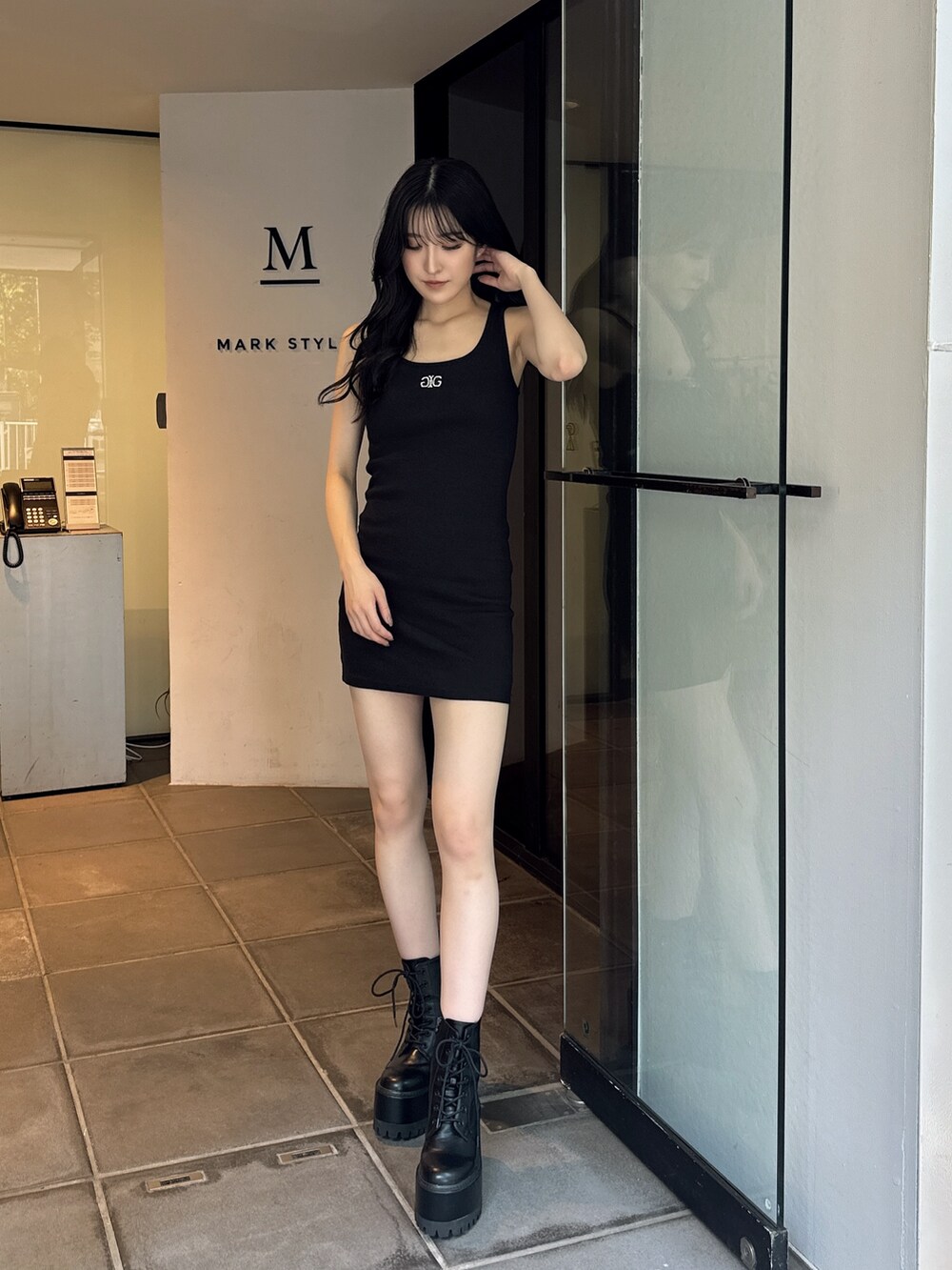 ブラック系のワンピース、ブラック系のブーツを着用したレディースの夏コーディネートの7枚目の写真