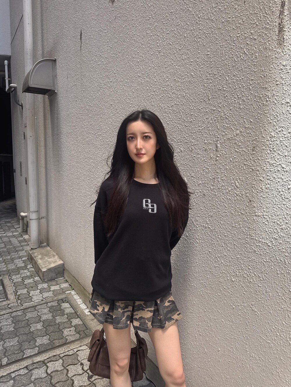 ブラック系のパーカー、その他のデニムスカート、ブラウン系のハンドバッグを着用したレディースの秋コーディネートの2枚目の写真