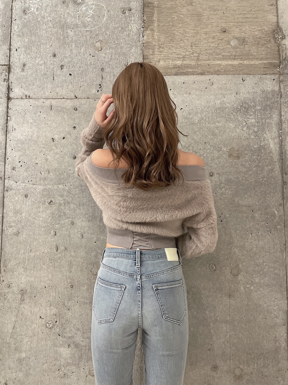 ベージュ系のニット/セーター、ブルー系のデニムパンツ、ホワイト系のパンプスを着用したレディースの秋コーディネートの3枚目の写真