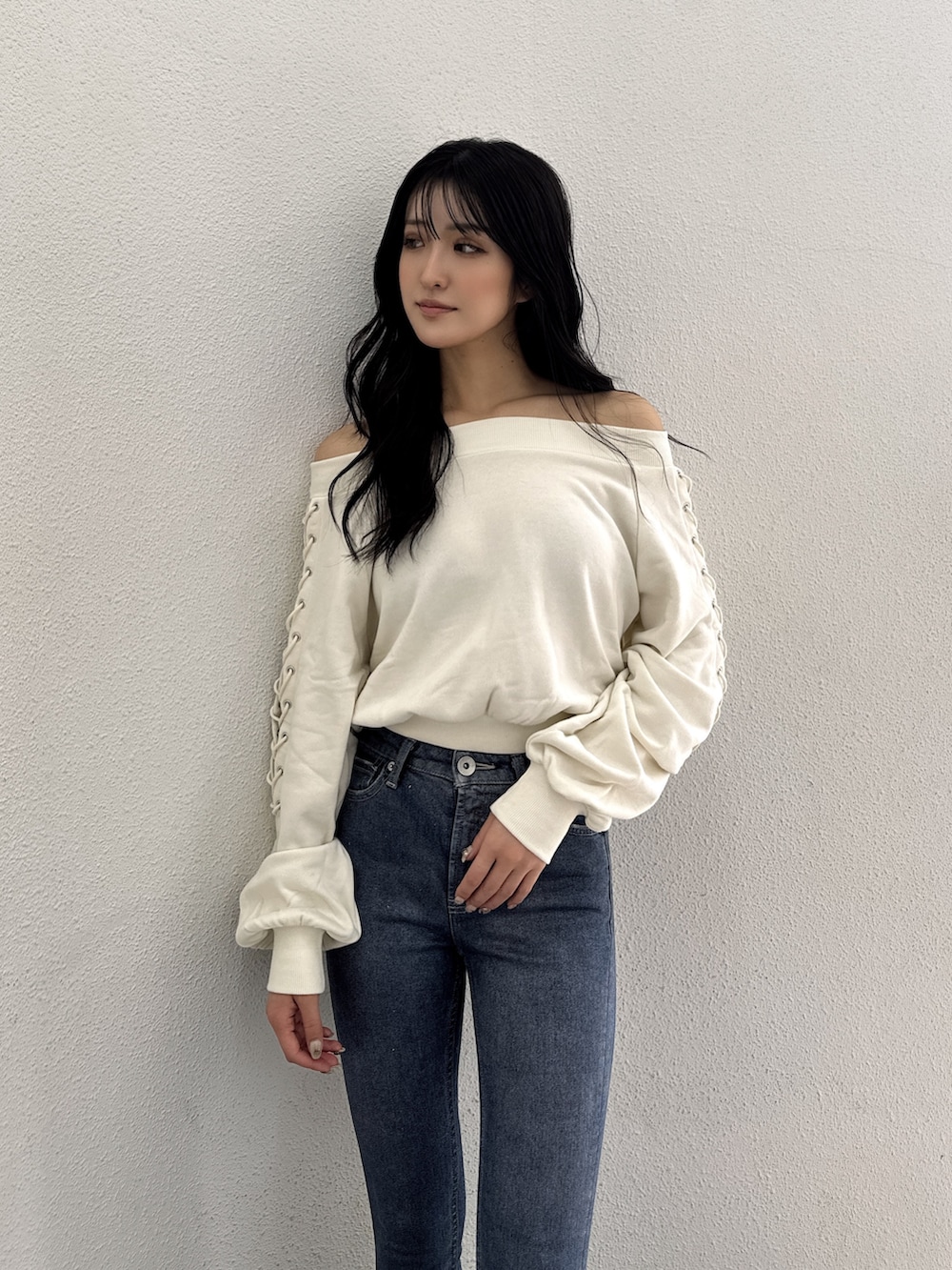 ホワイト系のスウェット、ブルー系のデニムパンツ、ブラック系のサンダルを着用したレディースの夏コーディネートの3枚目の写真