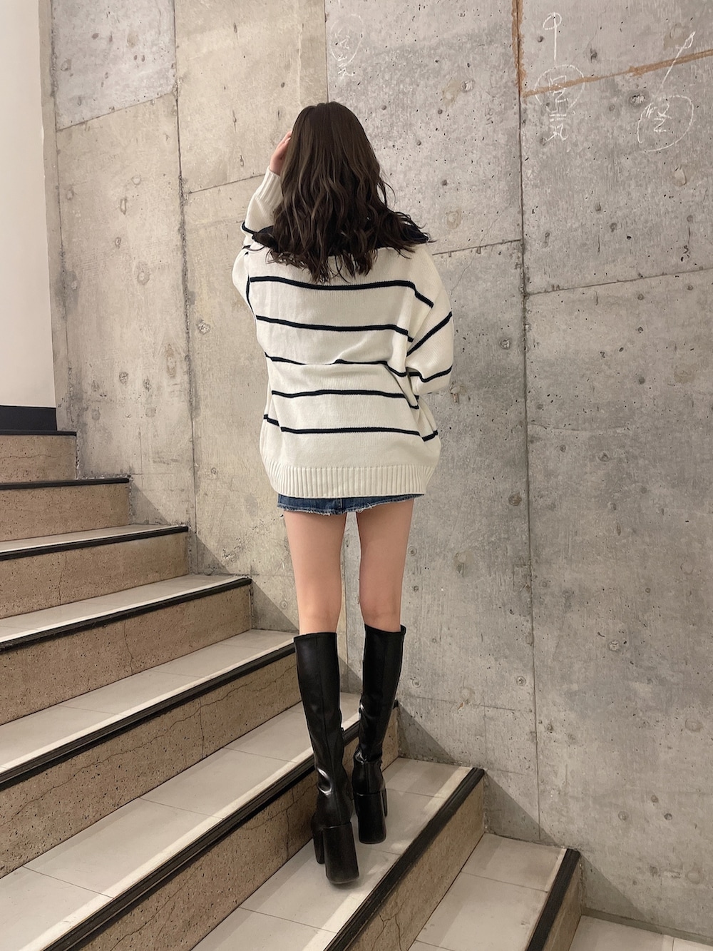 その他のニット/セーター、ブルー系のデニムスカート、ブラック系のブーツを着用したレディースの冬コーディネートの2枚目の写真